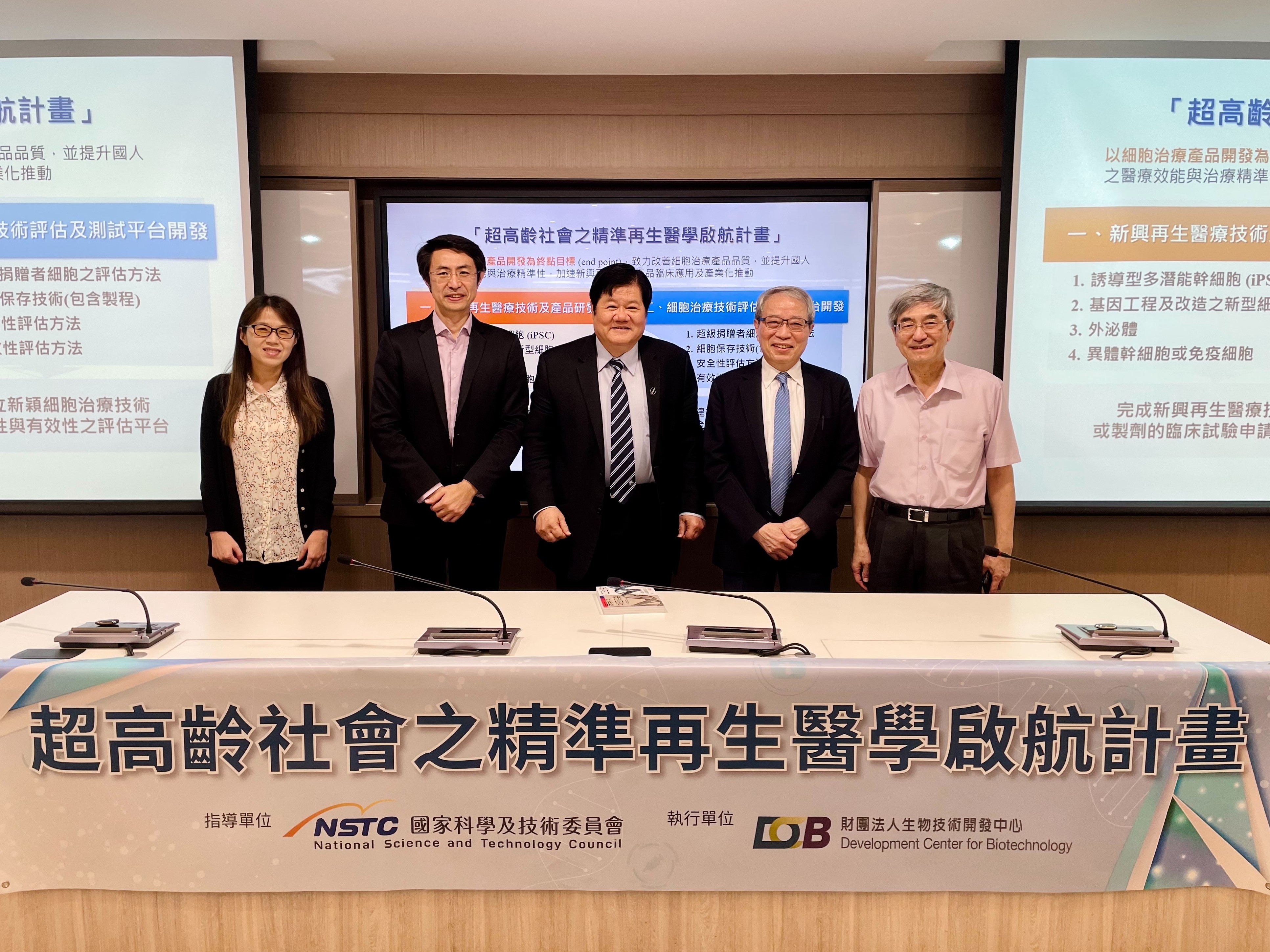 這張圖片展示了一個有五個人在台前的活動，他們站在一個標有「超高齡社會之精準再生醫學啟航計畫」的橫幅前。橫幅上還有「國家科學及技術委員會」和「財團法人生物技術開發中心」的標誌。
